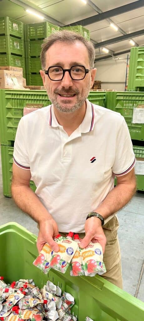 Eric SARAZIN, tenant dans ses mains la compote en gourde 100% fruits